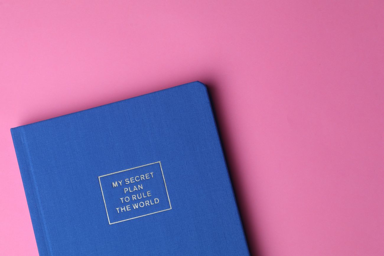 A blue notebook on a pink background