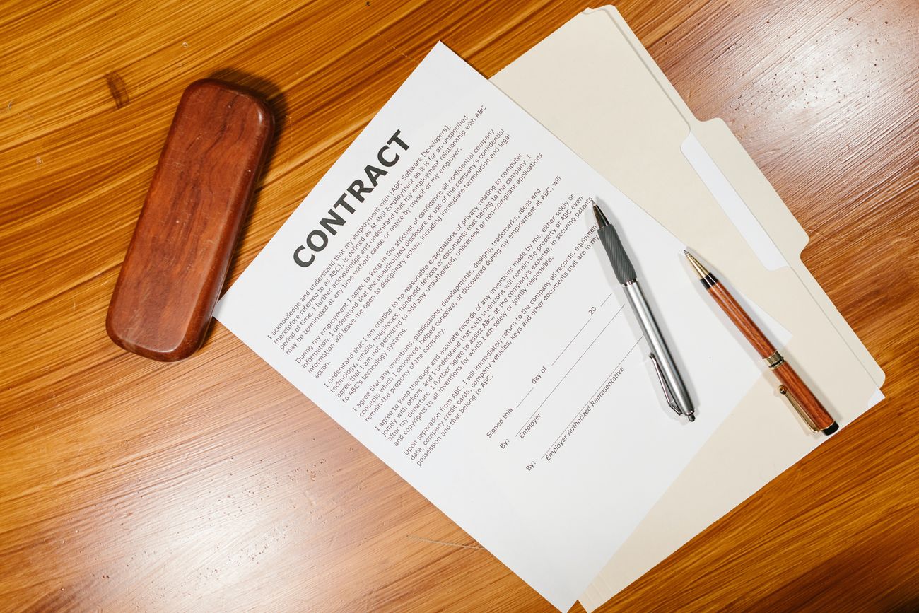 A contract and pen on a wooden desk