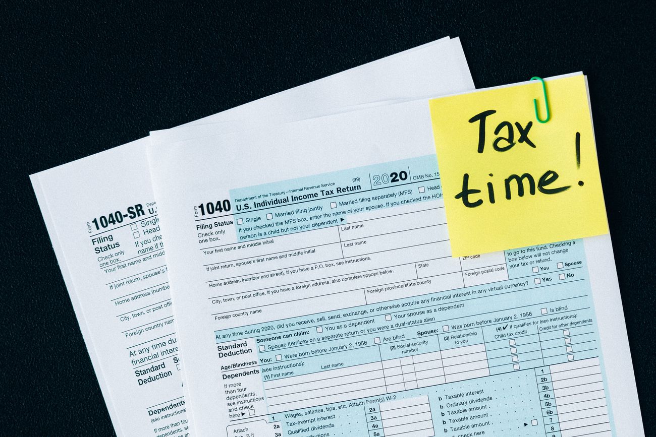 Tax forms with a sticky note that says