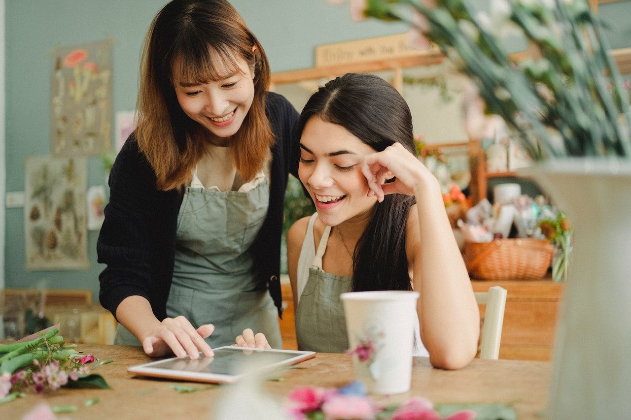 Two friends smiling together over a tablet