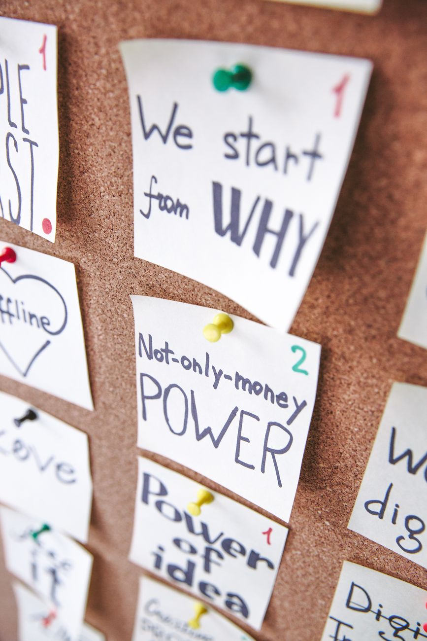 A cork board with notes reading We start from why